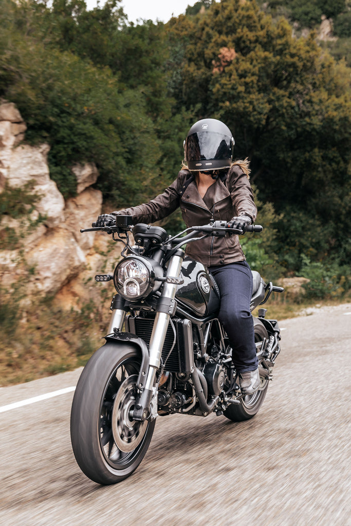 une motarde qui roule à moto avec sa veste protectrice